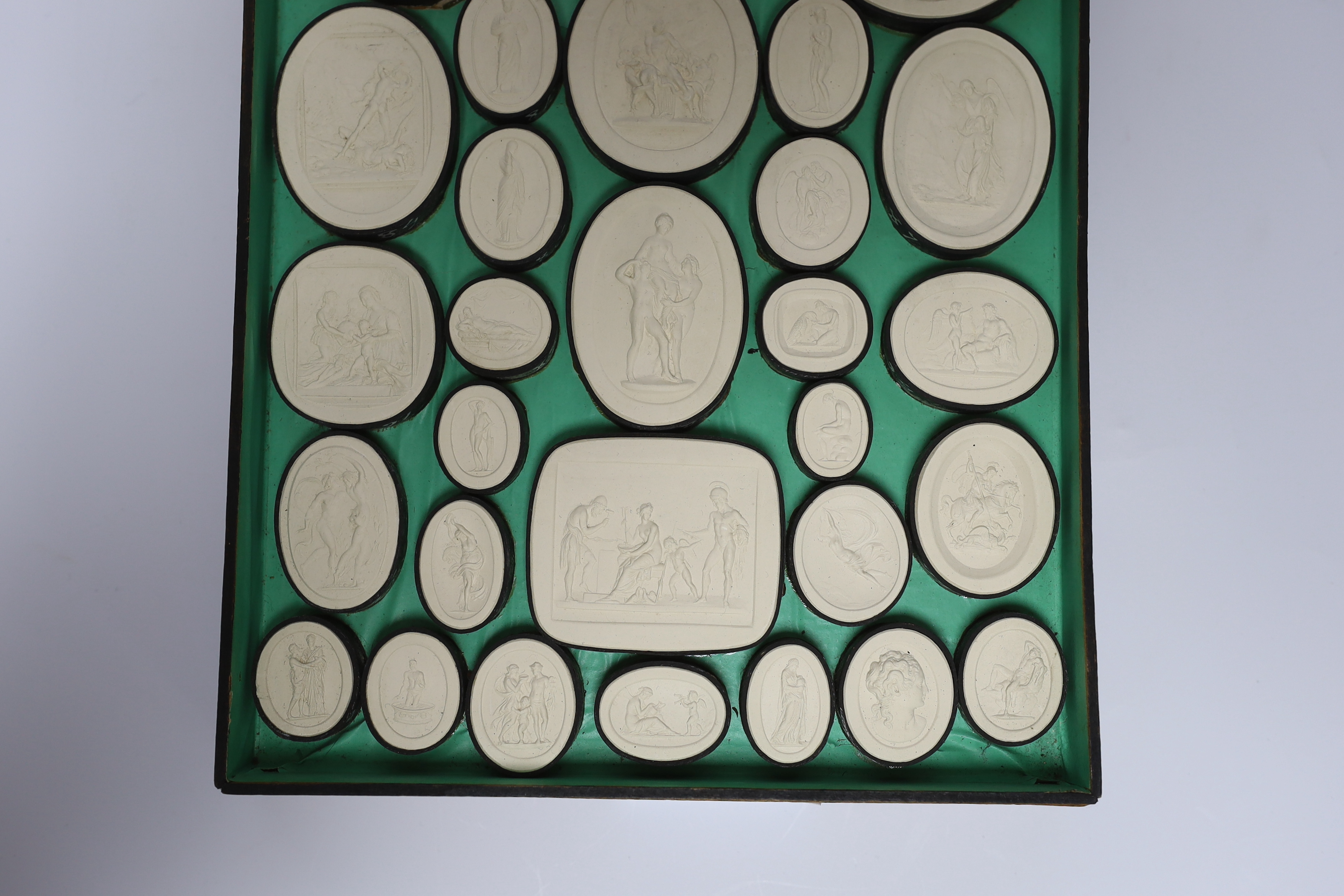 A cased set of thirty two Italian Grand Tour plaster roundels after intaglios of various subjects
